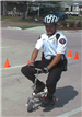officer on scooter rides around cones